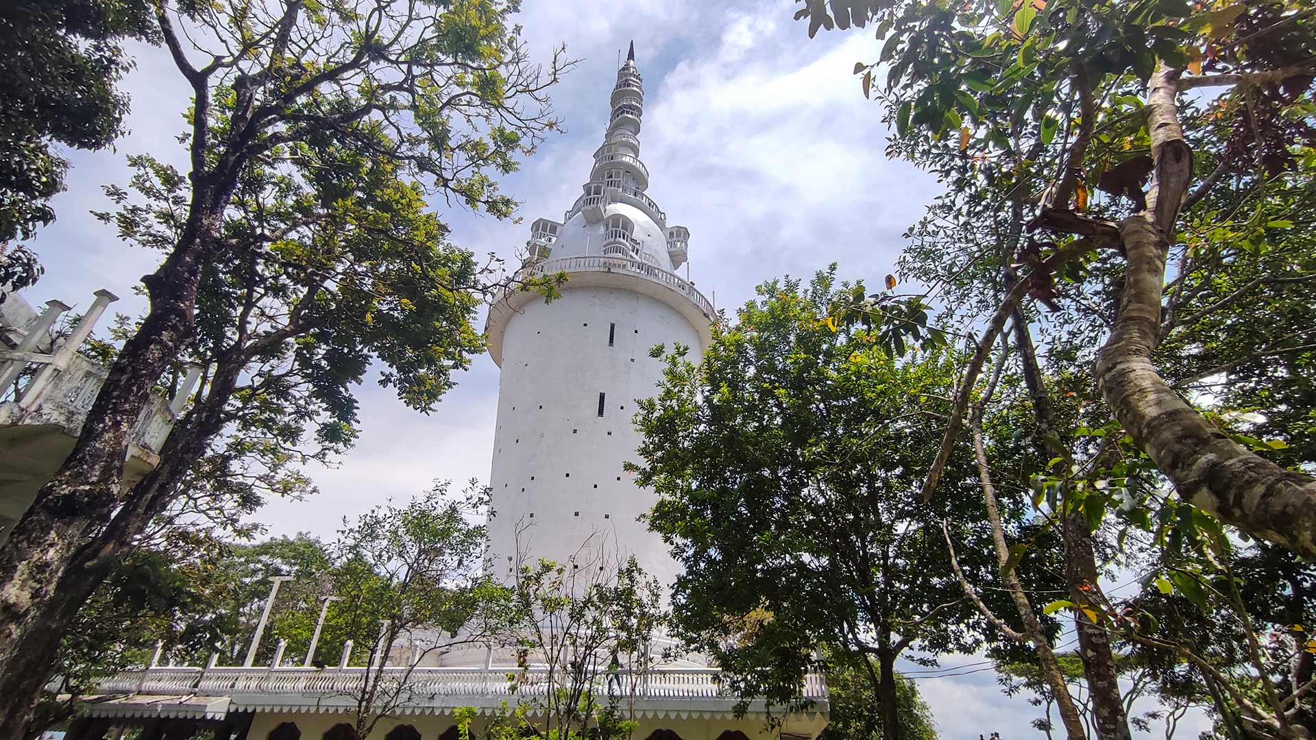 Ambuluwawa Tower — a distinctive white multi-tiered observation tower rising from forested hilltop near Gampola