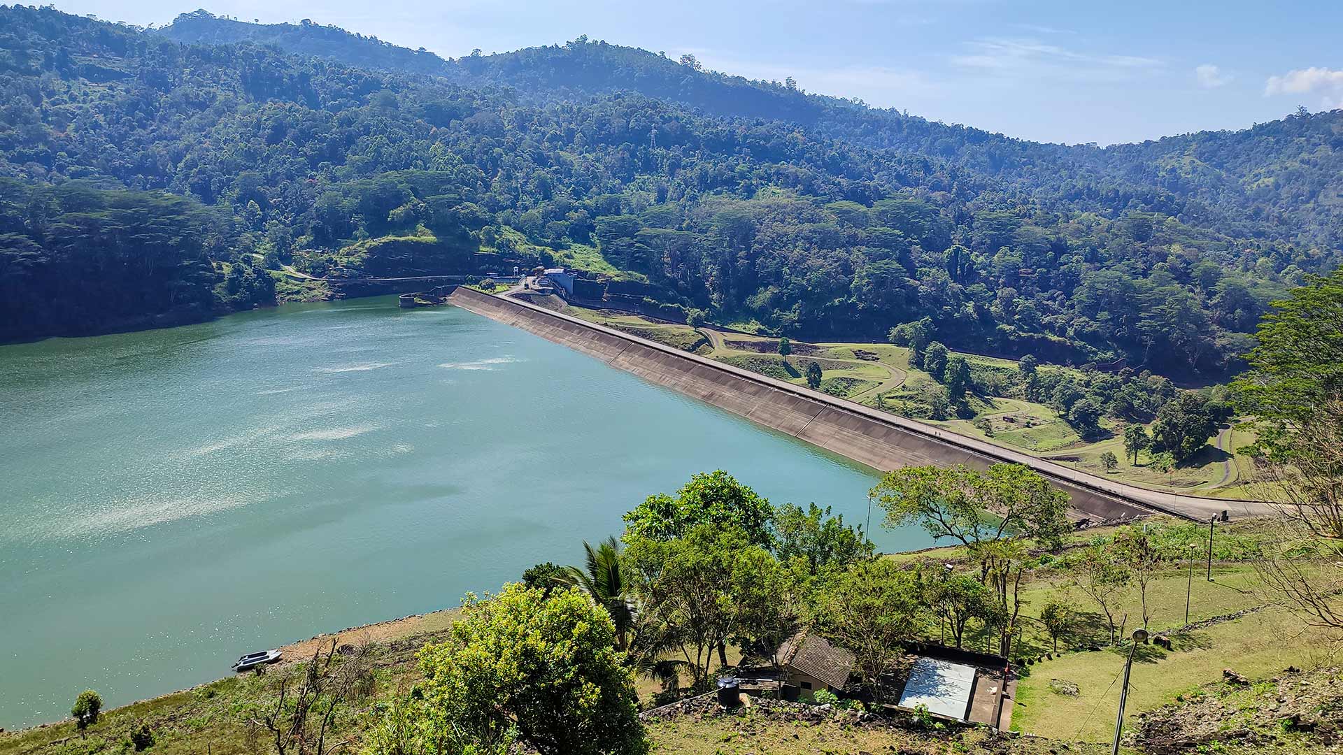Elevated view over Kotmale Reservoir and dam surrounded by forested highland hills